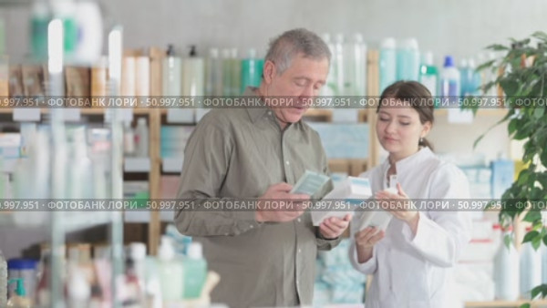 Man choosing cream with help from pharmacist. Стоковое видео, видеограф Яков Филимонов / Фотобанк Лори