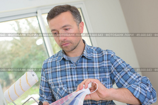 man choosing paint color and pent paper. Стоковое фото, агентство Ingram Publishing / Фотобанк Лори