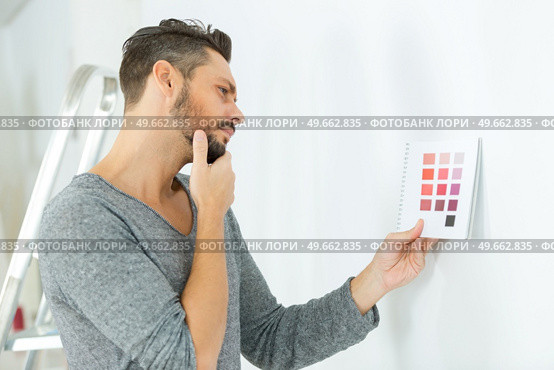 man considering colour scheme for wall. Стоковое фото, агентство Ingram Publishing / Фотобанк Лори