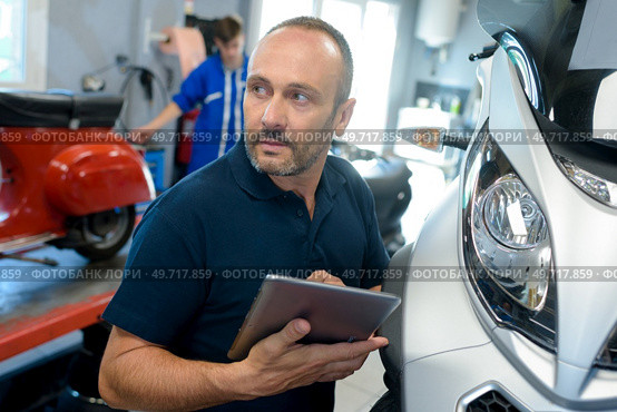 man fixing a motorcycle frame in workshop. Стоковое фото, агентство Ingram Publishing / Фотобанк Лори