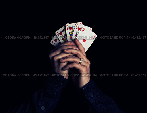 man hands holding playing cards with the strongest combination - royal flush. Стоковое фото, агентство Ingram Publishing / Фотобанк Лори