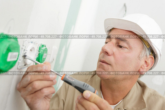 man holding small flat blade screwdriver. Стоковое фото, агентство Ingram Publishing / Фотобанк Лори