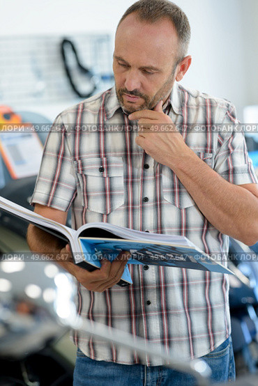 man in a motorcycle concessionary showroom. Стоковое фото, агентство Ingram Publishing / Фотобанк Лори