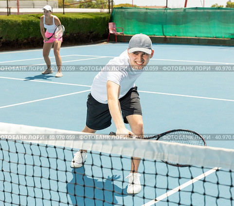 Man in shorts and t-shirt playing tennis on court. Racket sport training outdoors. Стоковое фото, фотограф Яков Филимонов / Фотобанк Лори