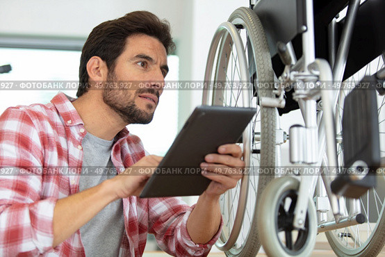 man is repairing a wheelchair at workshop. Стоковое фото, агентство Ingram Publishing / Фотобанк Лори