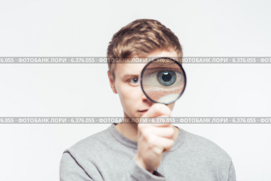 Man looking through a magnifying glass. Стоковое фото, агентство Ingram Publishing / Фотобанк Лори