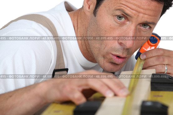 Man measuring piece wood. Стоковое фото, агентство Ingram Publishing / Фотобанк Лори