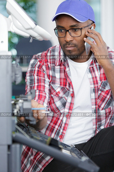 man on telephone next to broken photocopier. Стоковое фото, агентство Ingram Publishing / Фотобанк Лори