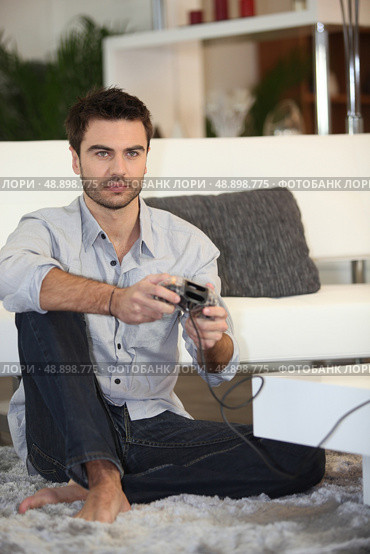 Man playing on console. Стоковое фото, агентство Ingram Publishing / Фотобанк Лори