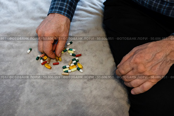 Man preparing medication on a soft surface at home during the afternoon. Стоковое фото, фотограф Вербицкая Светлана / Фотобанк Лори