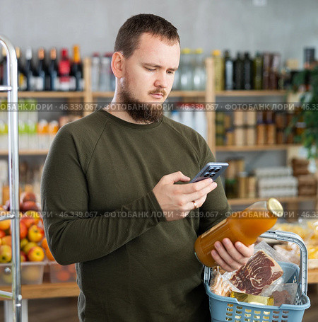 Man purchaser scanning QR code or barcode of bottle grapefruit in supermarket. Стоковое фото, фотограф Яков Филимонов / Фотобанк Лори