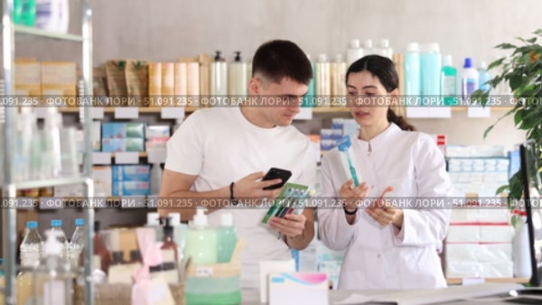 Man scans QR code on toothbrush label. Female pharmacist offers to choose the right toothbrush. Стоковое видео, видеограф Яков Филимонов / Фотобанк Лори