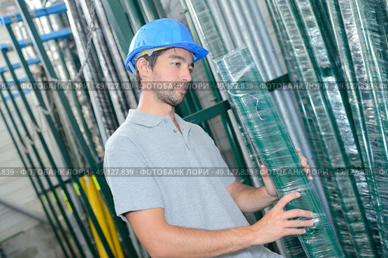 Man selecting shrink wrapped pack of poles. Стоковое фото, агентство Ingram Publishing / Фотобанк Лори
