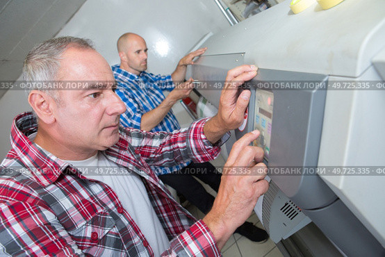 man setting a professional printer. Стоковое фото, агентство Ingram Publishing / Фотобанк Лори