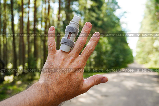 Man showing injured finger with splint in forest road. Стоковое фото, фотограф Дмитрий Цветков / Фотобанк Лори