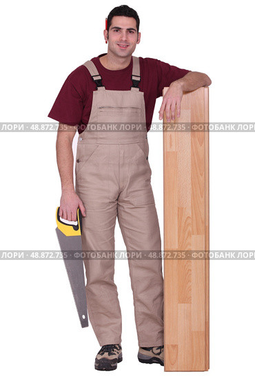 Man stood with laminate flooring and saw. Стоковое фото, агентство Ingram Publishing / Фотобанк Лори