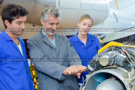 Man trying to lever aircraft component. Стоковое фото, агентство Ingram Publishing / Фотобанк Лори