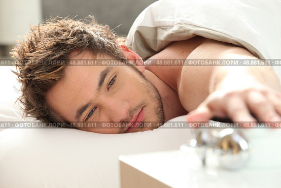 Man turning off alarm clock. Стоковое фото, агентство Ingram Publishing / Фотобанк Лори
