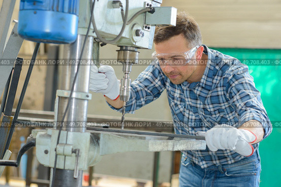 man using a metal driller. Стоковое фото, агентство Ingram Publishing / Фотобанк Лори