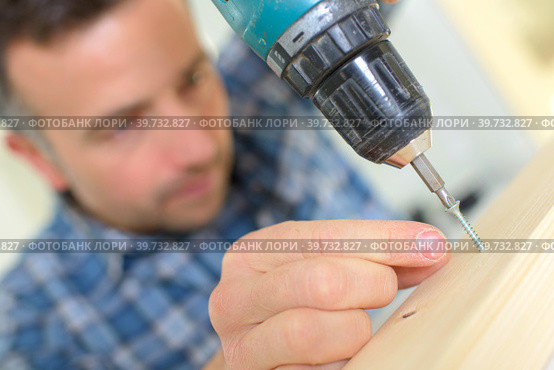 Man using an electric screwdriver. Стоковое фото, фотограф Phovoi R. / Smarterpix / Фотобанк Лори
