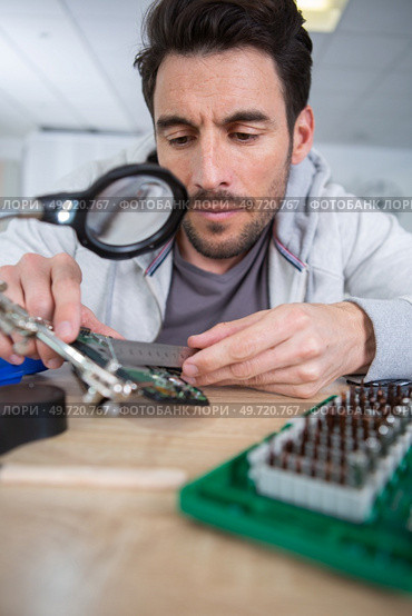 man using plier to assemble printed circuit board. Стоковое фото, агентство Ingram Publishing / Фотобанк Лори