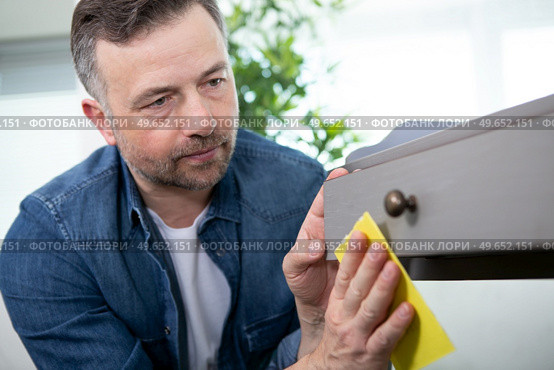 man using sandpaper on a painted cupboard. Стоковое фото, агентство Ingram Publishing / Фотобанк Лори