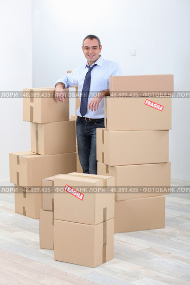 Man with piles of cardboard boxes marked fragile. Стоковое фото, агентство Ingram Publishing / Фотобанк Лори