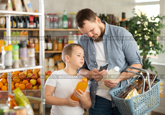 Man with preteen son scanning barcode on drink bottles in grocery store. Стоковое фото, фотограф Яков Филимонов / Фотобанк Лори