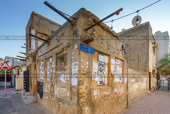 Manama, Bahrain - Jan 08 2024, View of the corner of an old dilapidated one-story house with a license plate, in the evening, Manama, Bahrain. Стоковое фото, фотограф Сергей Богомяко / Фотобанк Лори