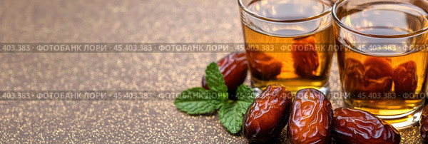 Марокканский праздник Ид аль-Фитр, плоский стол с финиками и чаем на сверкающей поверхности. Стоковое AI-изображение, AI-художник ФотоИнтеллект / Фотобанк Лори