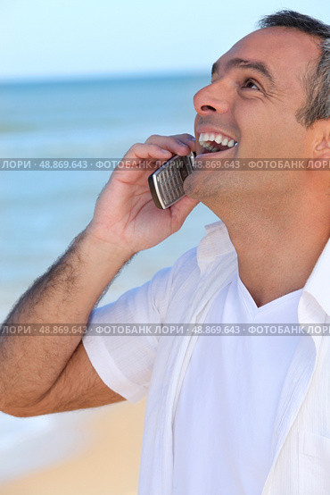 Mature man laughing into his cellphone. Стоковое фото, агентство Ingram Publishing / Фотобанк Лори