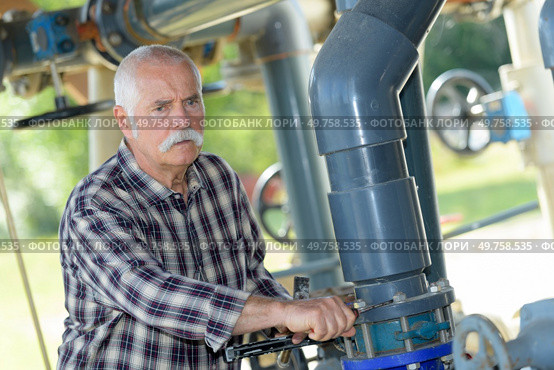 mature man standing on waste water treatment unit. Стоковое фото, агентство Ingram Publishing / Фотобанк Лори