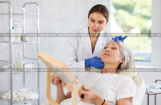 Mature patient with mirror, doctor with gloves. Стоковое фото, фотограф Яков Филимонов / Фотобанк Лори