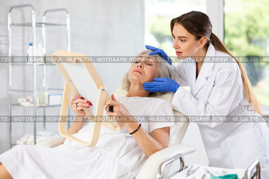Mature patient with mirror, doctor with gloves. Стоковое фото, фотограф Яков Филимонов / Фотобанк Лори