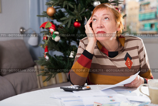 Mature woman calculates utility costs in the new year. Стоковое фото, фотограф Яков Филимонов / Фотобанк Лори