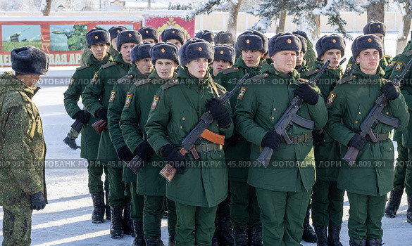Maykop, Russia - January 13, 2024: An officer and young soldiers in green dress uniforms with Kalashnikov assault rifles stand on the parade ground on a winter morning. Редакционное фото, фотограф Андрей С / Фотобанк Лори