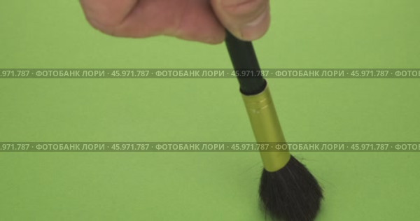 Мазки кистью для макияжа на зеленом фоне. Выделена рука, держащая кисточку для макияжа. Крупный план. Стоковое видео, видеограф Александр Собко / Фотобанк Лори