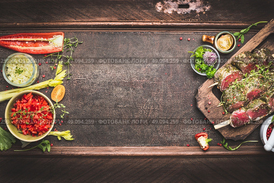 Meat skewers with vegetables and fresh flavoring, preparation for grill or BBQ on dark vintage background, top view, banner. Стоковое фото, агентство Ingram Publishing / Фотобанк Лори