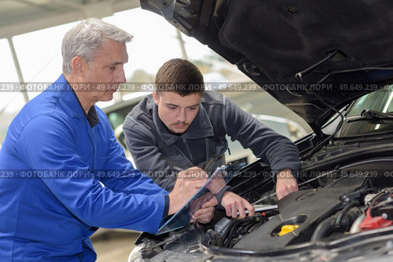 mechanic checked in the engine compartment of a car. Стоковое фото, агентство Ingram Publishing / Фотобанк Лори