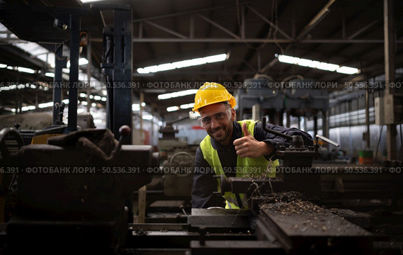 Mechanical engineers enter the old machinery warehouse to inspect and repair used machinery with the warehouse’s personnel. Стоковое фото, агентство Ingram Publishing / Фотобанк Лори