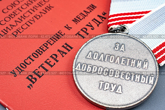 Медаль ветерана труда за долголетний добросовестный труд лежит на удостоверении к медали (2024 год). Редакционное фото, фотограф Анна Аникова / Фотобанк Лори