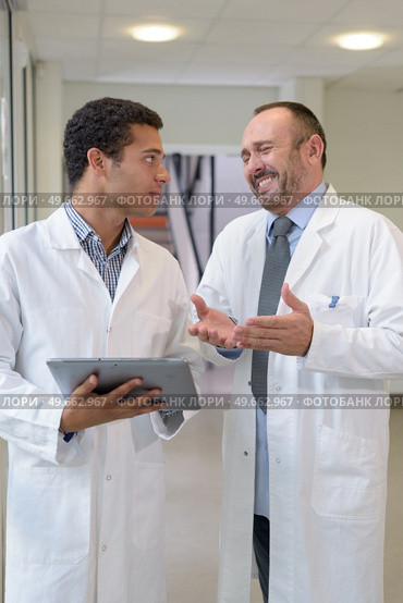 medic laughing at colleagues tablet. Стоковое фото, агентство Ingram Publishing / Фотобанк Лори
