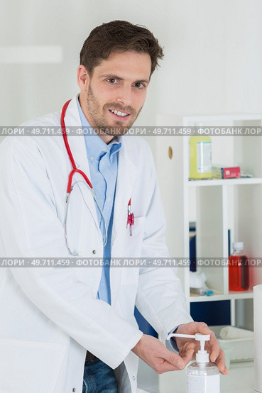 medical doctor using sanitizer dispenser in clinic. Стоковое фото, агентство Ingram Publishing / Фотобанк Лори