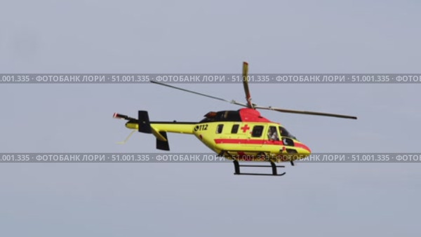 Medical helicopter, bearing team of rescuers, descends swiftly during critical situation, while group of onlookers gathers on ground below. Стоковое видео, видеограф Strunov David / Фотобанк Лори
