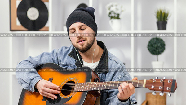 medium shot musician playing guitar. Стоковое фото, агентство Ingram Publishing / Фотобанк Лори