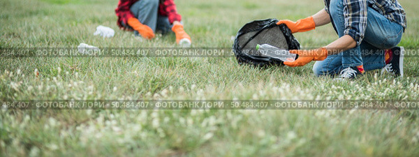 Men and women helped to collect garbage in a black bag. Стоковое фото, агентство Ingram Publishing / Фотобанк Лори
