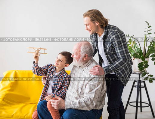 men different generations looking toy plane. Стоковое фото, агентство Ingram Publishing / Фотобанк Лори