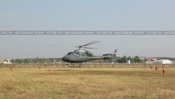 Международный авиационно-космический салон МАКС-2015. Полицейский вертолет Eurocopter AS 355N Ecureuil совершает посадку в поле. Редакционное видео, видеограф Игорь Долгов / Фотобанк Лори