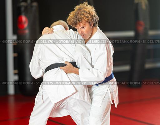 Middle‑aged aikido practitioner training with partner in dojo. Стоковое фото, фотограф Яков Филимонов / Фотобанк Лори