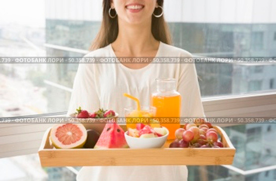 midsection woman holding wooden tray with many fruits juice. Стоковое фото, агентство Ingram Publishing / Фотобанк Лори